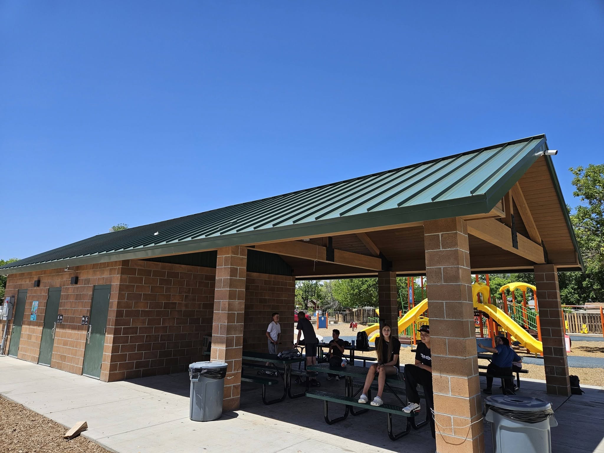 Workers install metal roofing on the wooden roof of a house. Technology